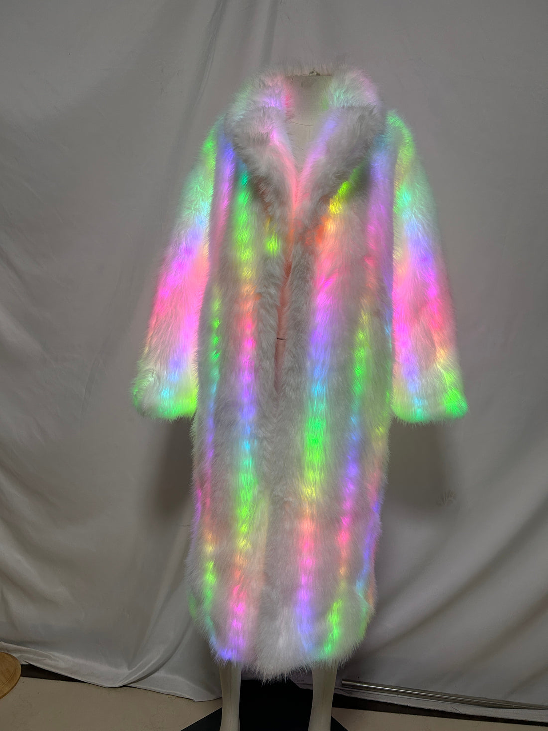 Woman's white LED faux fur long coat glowing in rainbow colors on a mannequin, front view